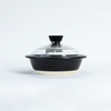 A black ceramic casserole dish with a clear glass lid and black knob, set against a plain white background.