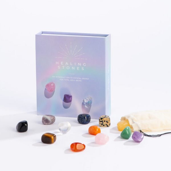 Blue gray box of Healing Stones with colorful stones and small drawstring bag in front of the box