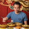 Man wearing the Jing Fong T-Shirt - Steel Blue while eating dim sum.