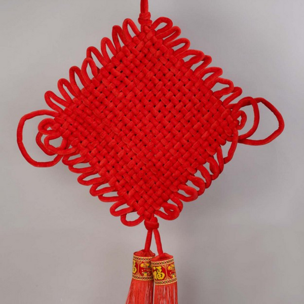 Red braided giant diamond knot ornament. Tassels shown as well