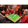 Group of people playing mahjong together in a casual setting.