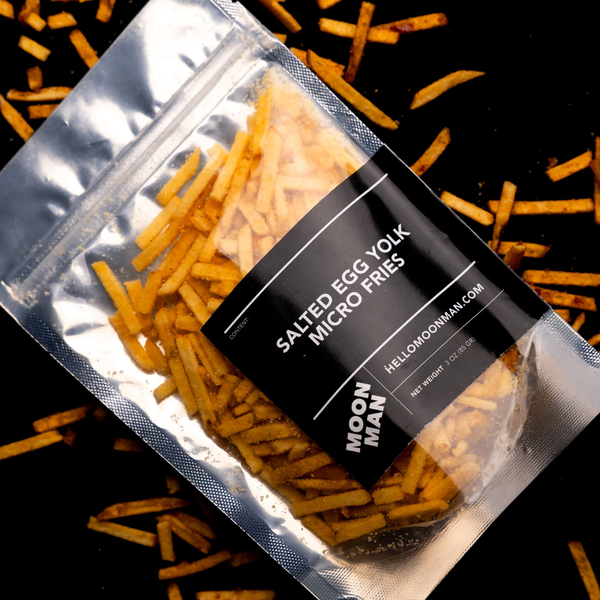 Packaged salted egg yolk micro fries with visible branding on a dark background.