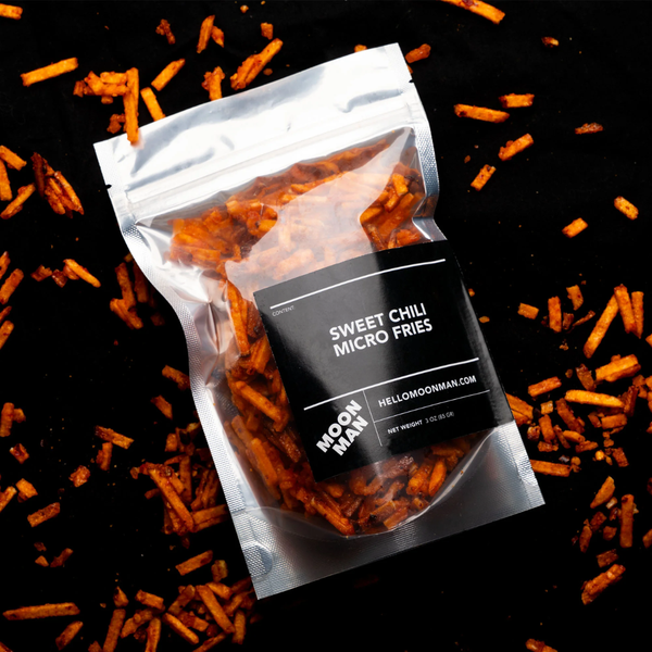 Package of Sweet Chili Micro Fries with scattered fries on a black background