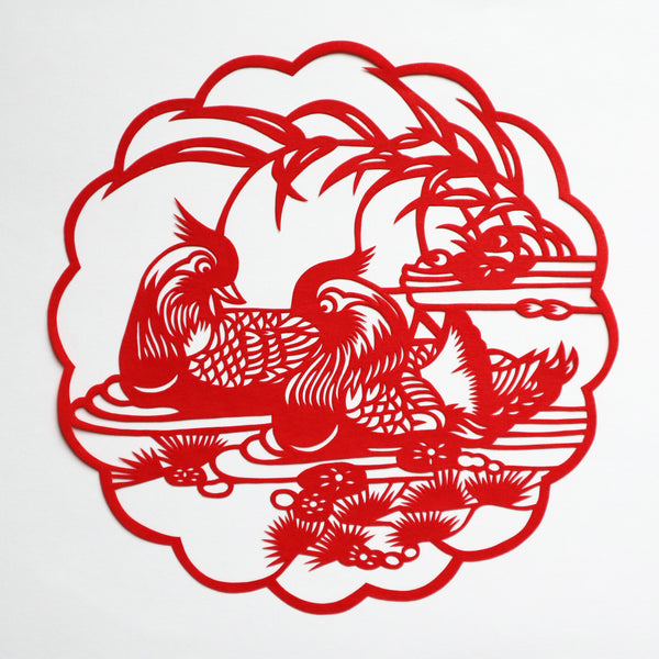 Red paper cut decoration with pair of mandarin ducks in water