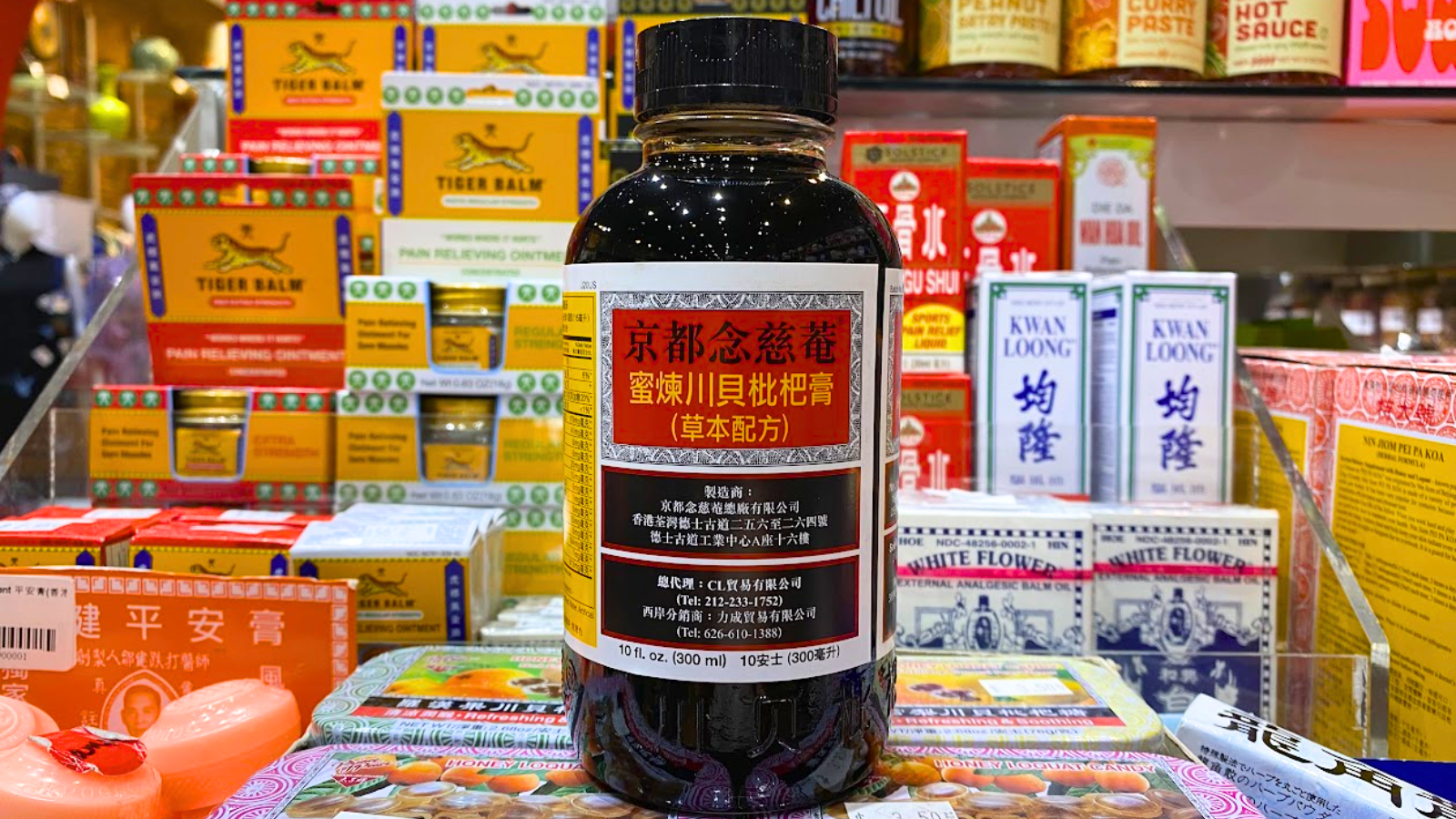 Bottle of Pei Pa Kao cough syrup in front of other Chinese medicines