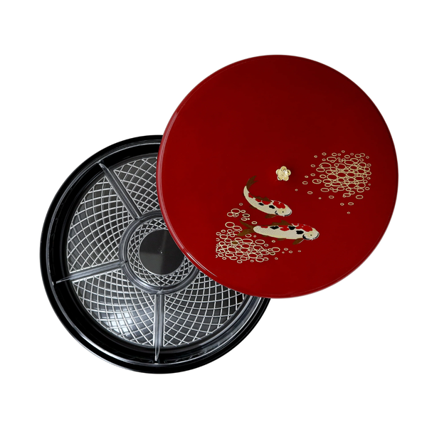 Red lid with fish design on a black circular tray