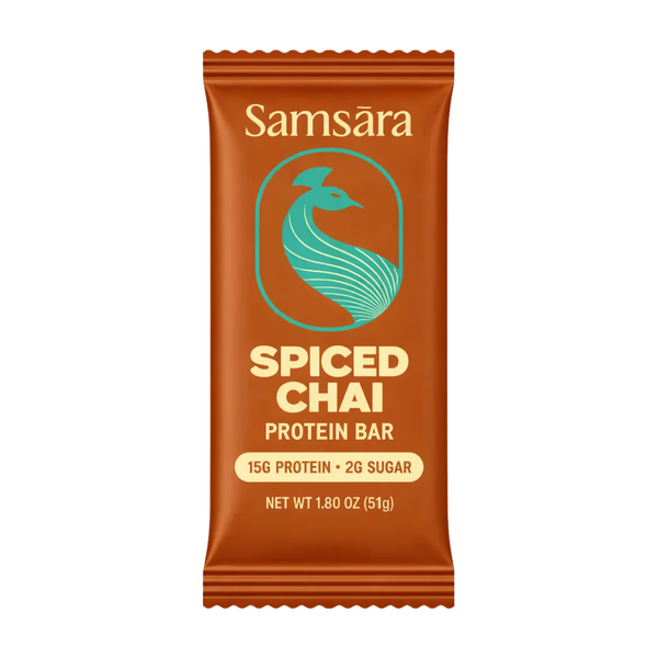 A single Samsára Spiced Chai protein bar in its wrapper packaging, shown against a plain white background. The wrapper is a warm orange-brown color with a teal logo and cream text.