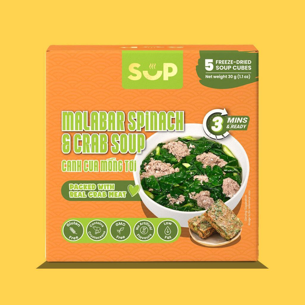 A box of SUP Malabar Spinach & Crab Soup freeze-dried soup cubes, featuring an orange packaging design with green and white text and a bowl of prepared soup on the front, set against a solid yellow background.