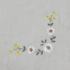 Embroidered floral design on a gray tablecloth