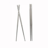 Two pairs of metal chopsticks with textured design on a white background